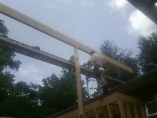 Carpenter setting a ridge beam over a new addition frame — Ice Dam Removal by Roofing Brothers in Copper Hill