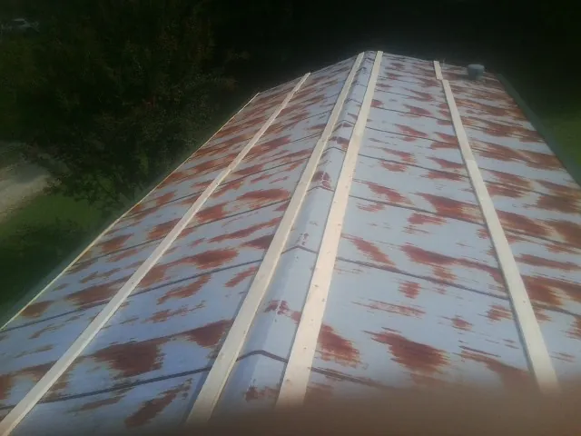 Rusted metal roof panels with new wood purlins before replacement — Storm Damage Roof Repair in Copper Hill by Roofing Brothers