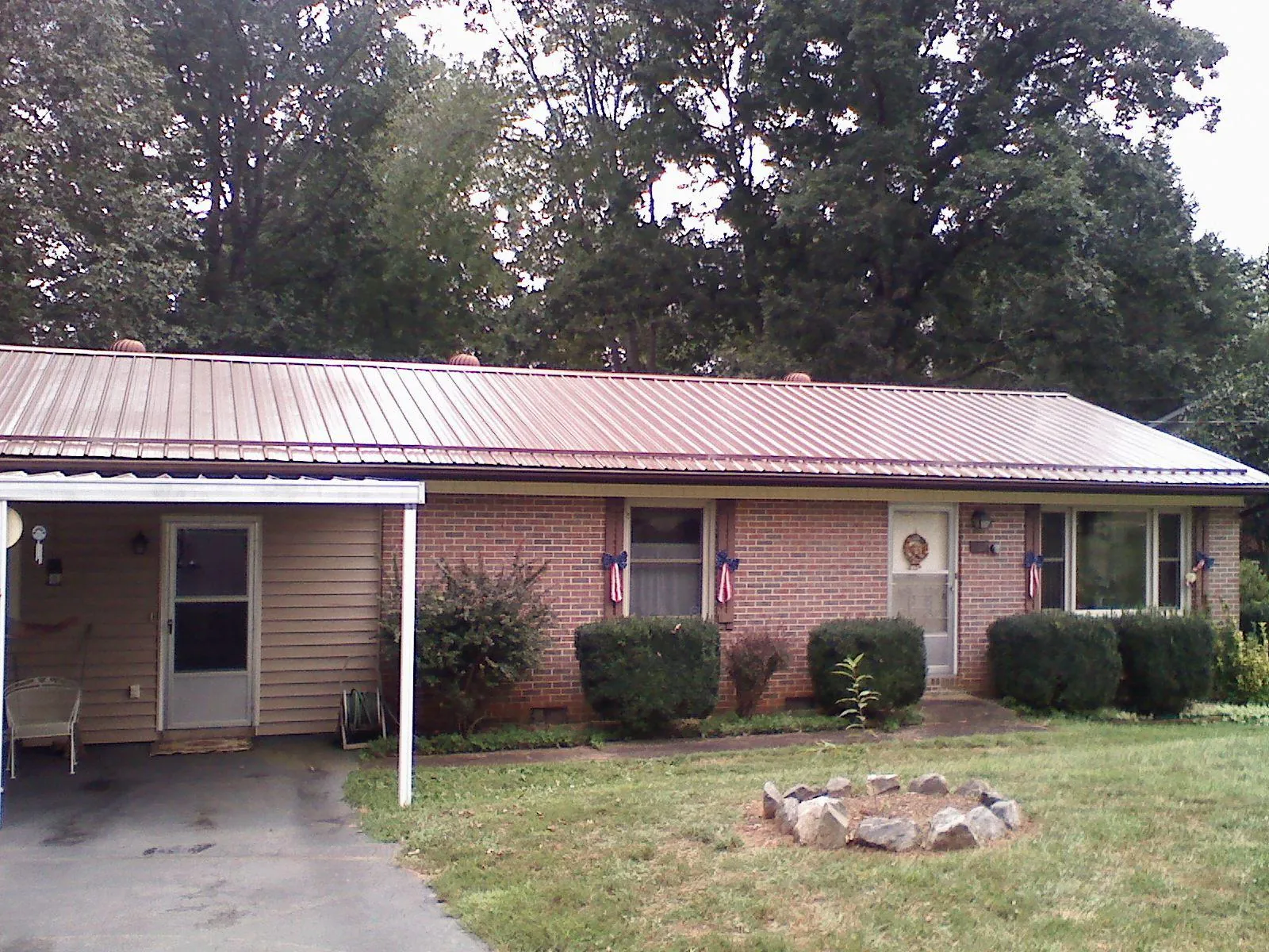 Bronze metal roof and carport on a brick ranch home — Roof Repair work by our crew in Copper Hill